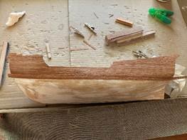 A wooden boat with tools on the floor Description automatically generated A wooden boat with tools on the floor Description automatically generated