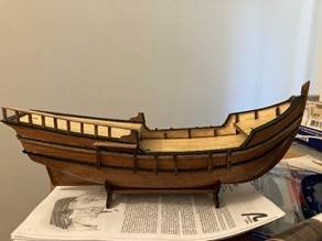 A model of a ship on a book Description automatically generated A model of a ship on a book Description automatically generated