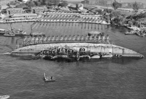 NASPH_^118506-_19_March_1943._USS_Oklahoma-_Salvage._Aerial_view_toward_shore_with_ship_in_90_...jpg