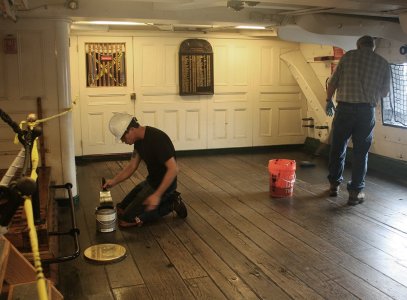 2016 July - Restorers apply a coat of stain to Constitution‘s gun deck in front of the Captain...jpg