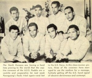 North_Korea_Propaganda_Photograph_of_prisoners_of_the_USS_Pueblo,_with_the_Hawaiian_Good_Luck_...jpg